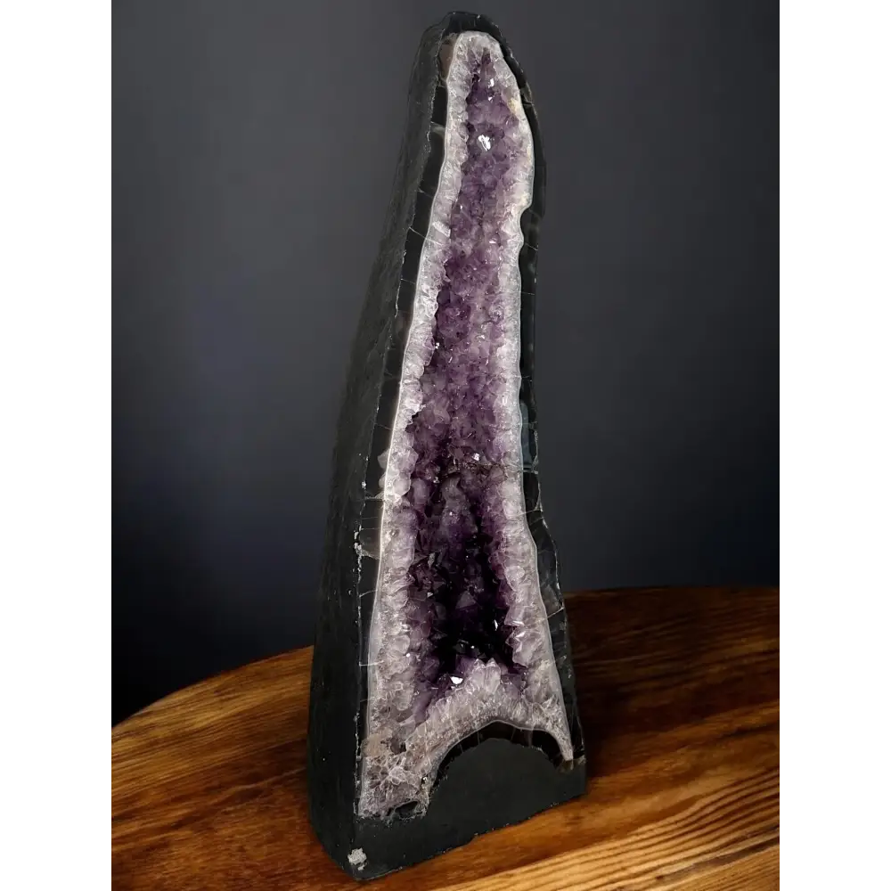 Amethyst-Druse mit dunklem äußeren Geode und violellen Kristallen sichtbar