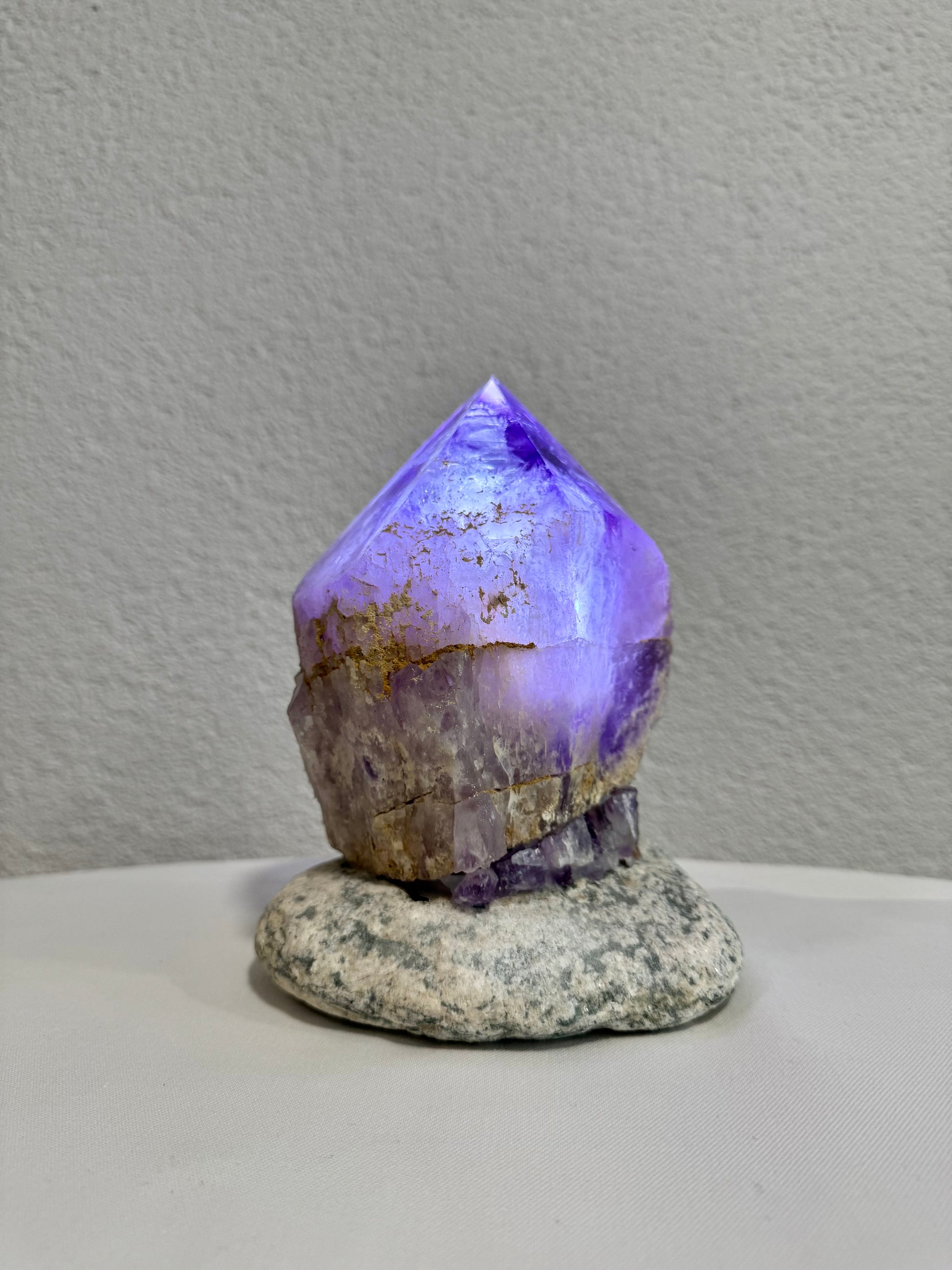 Leuchtende Amethystspitze auf Natursteinbasis aus Uruguay, präsentiert im Mineralienhotel Natznerhof, Südtirol