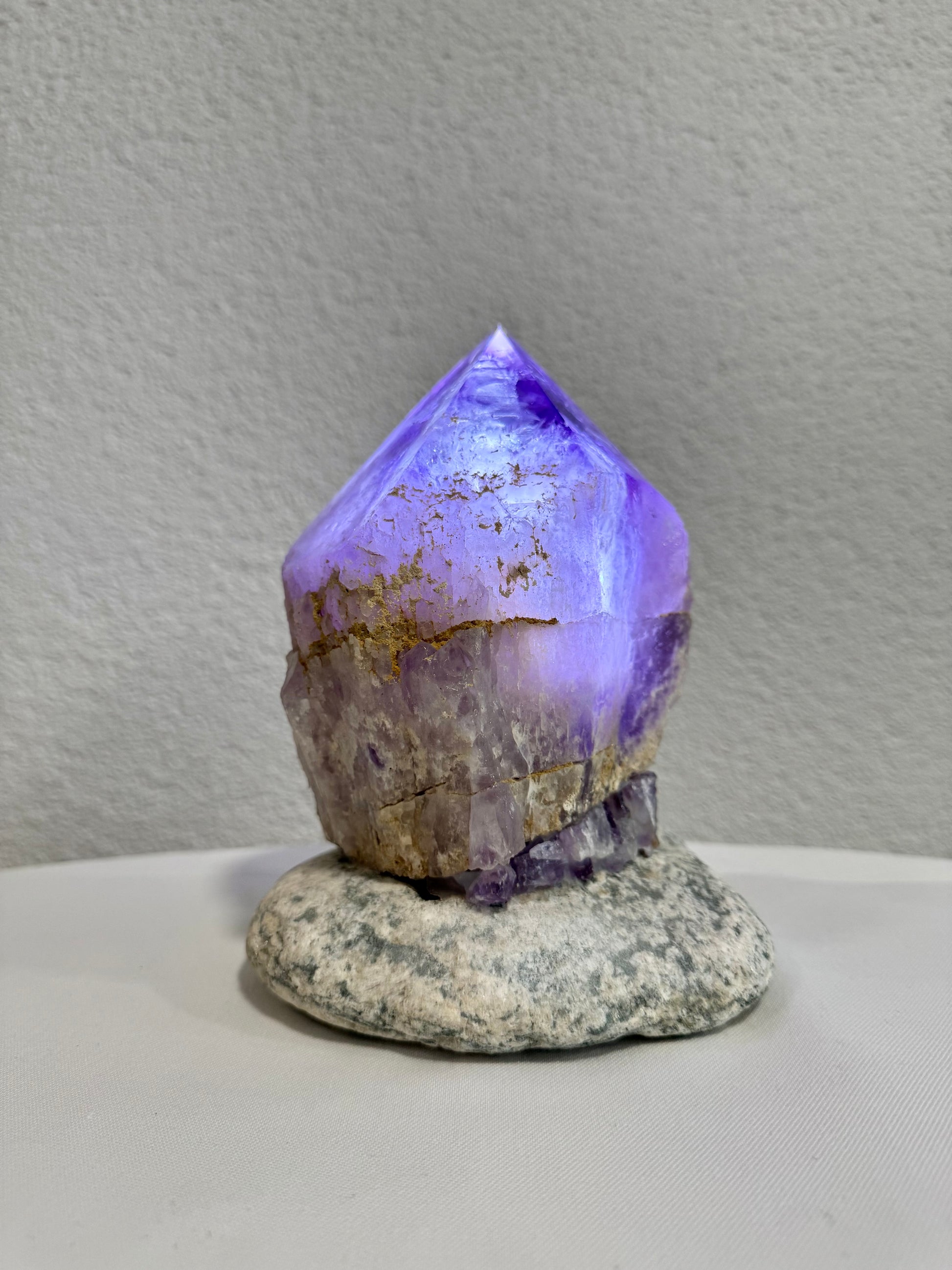 Amethystspitze mit violettem Schimmer auf natürlichem Stein, handgefertigte Lampe aus Uruguay, präsentiert im Mineralienhotel Natznerhof in Südtirol