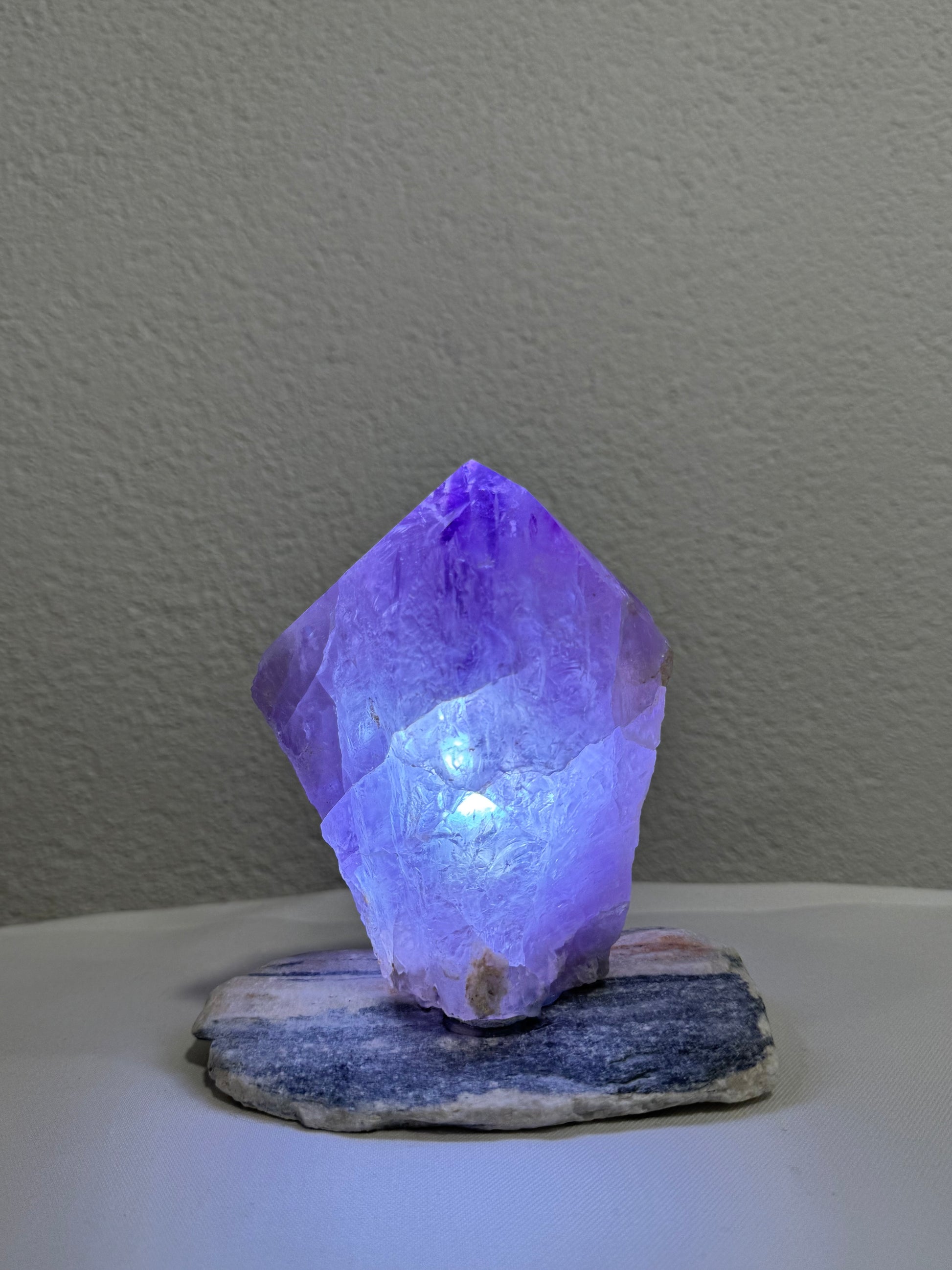 Wunderschön leuchtender Amethyst-Kristall, perfekt zur Raumgestaltung und als Sammlerstück, präsentiert auf einem einzigartigen Steinsockel