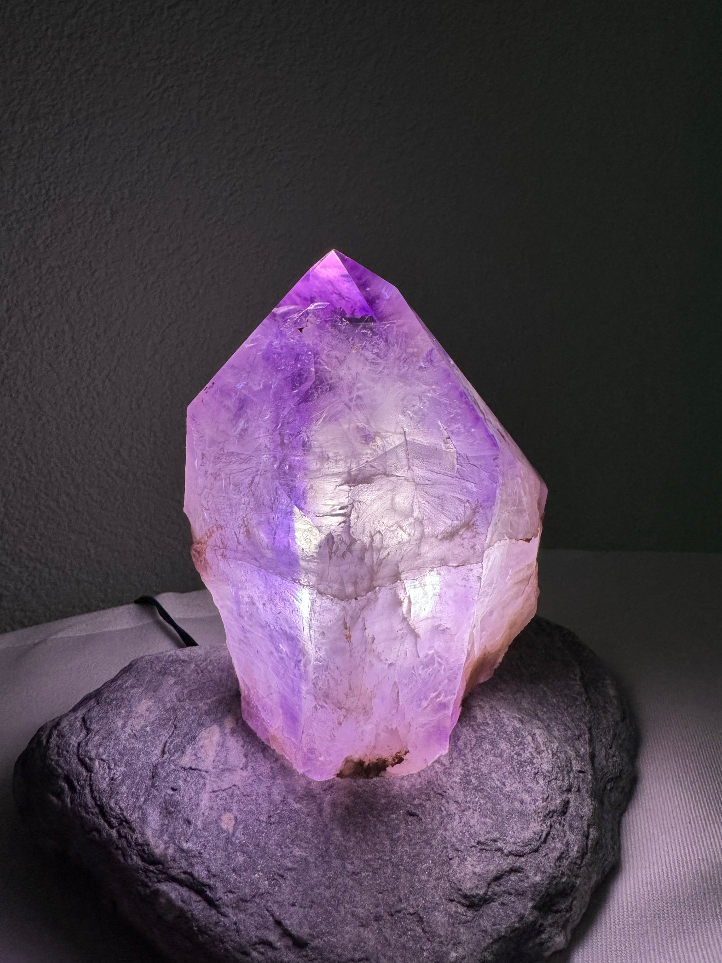 Amethyst Kristall auf Steinbasis, leuchtendes Violett, perfekt als stilvolle Tischlampe