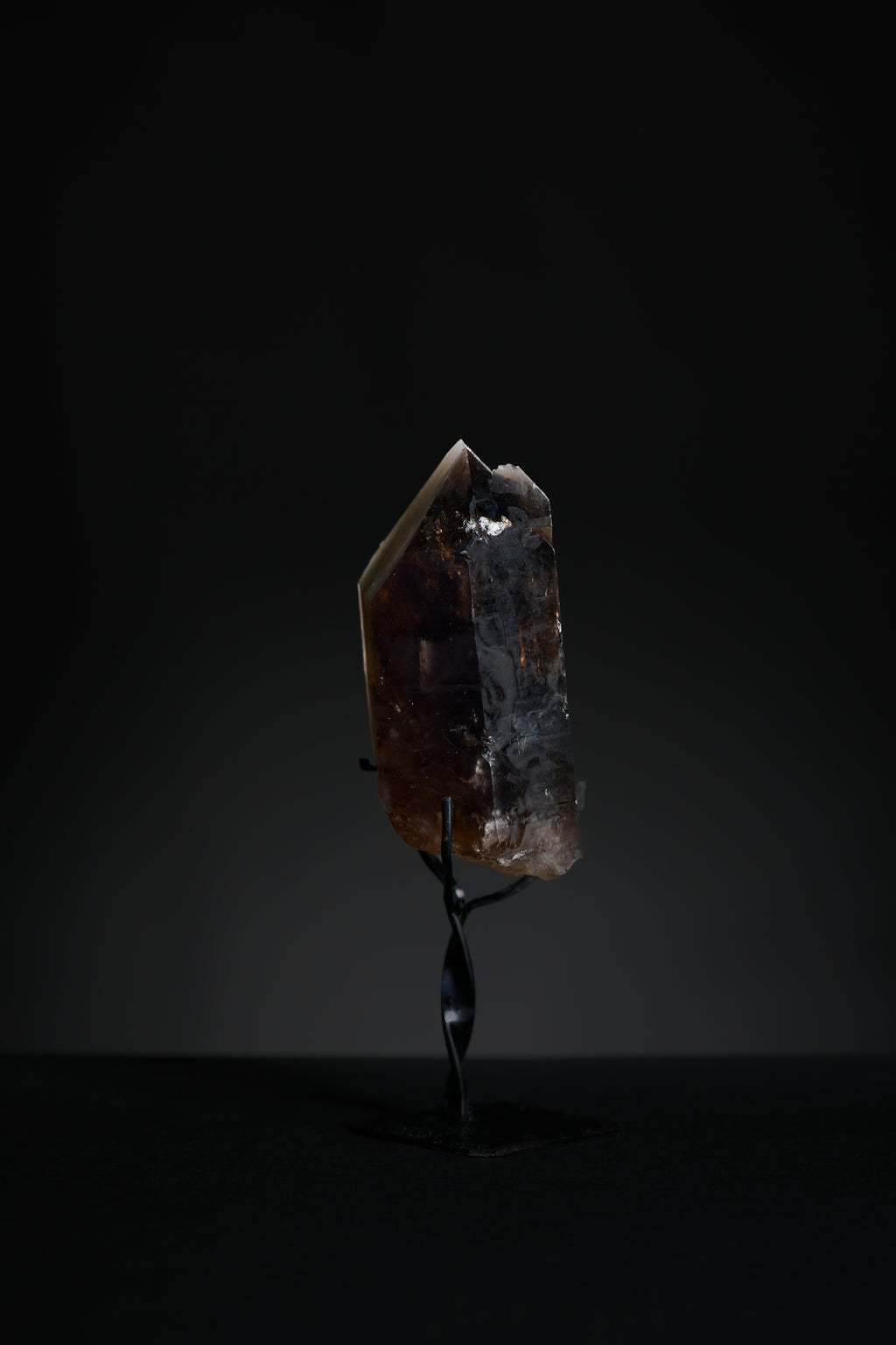Close-up of small smoky quartz point tip showing translucent brown crystal