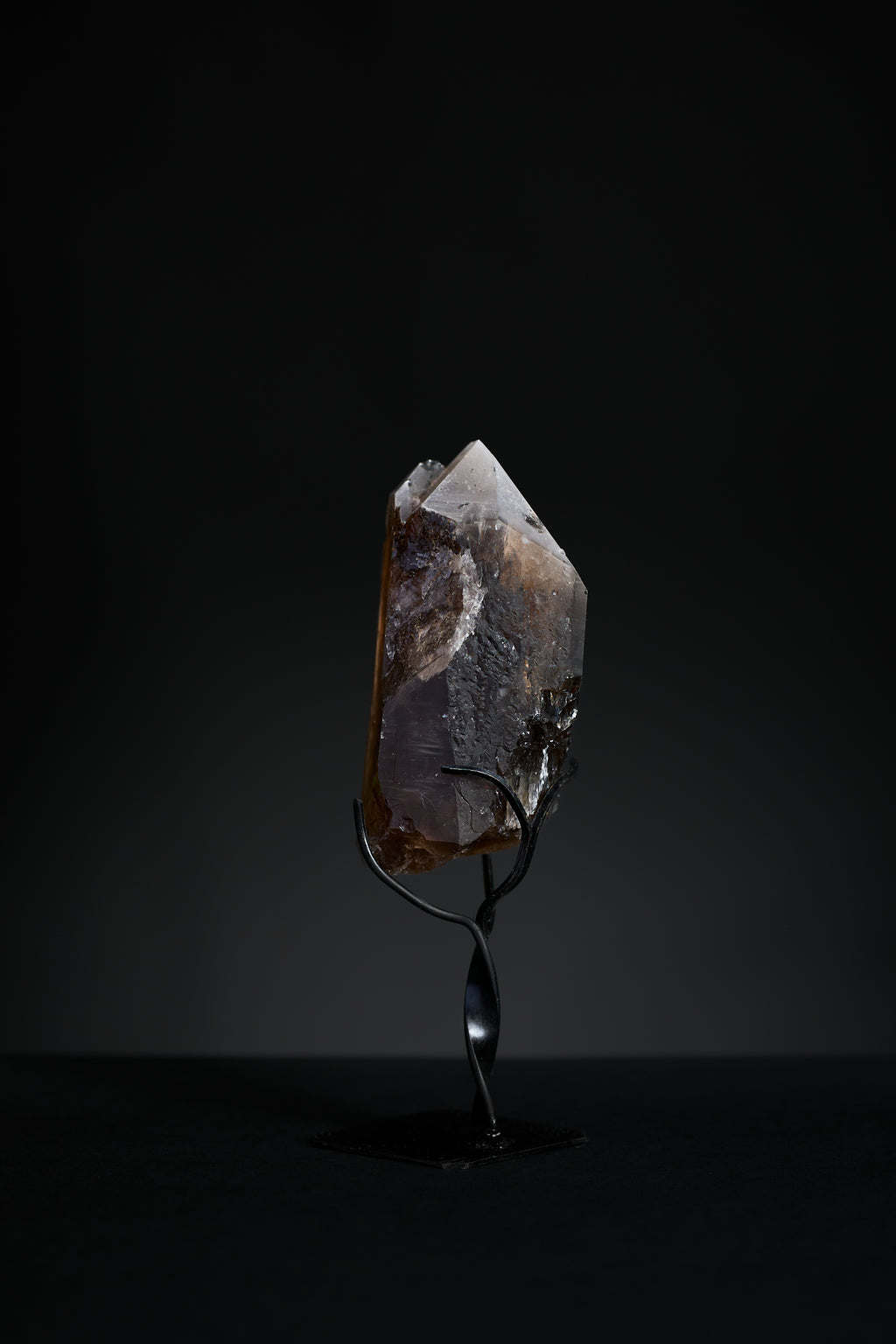Back view of small smoky quartz point showing natural surface