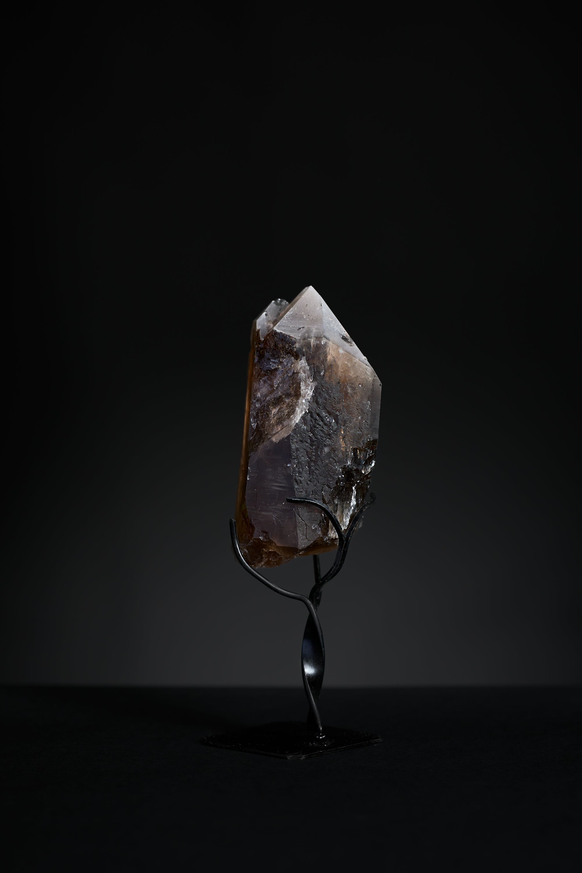 Back view of small smoky quartz point showing natural surface